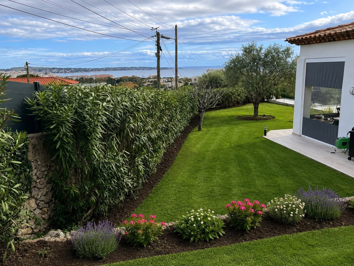 Jardin méditerranéen entretenu par Bonfi Garden, pelouse tondue et vue mer